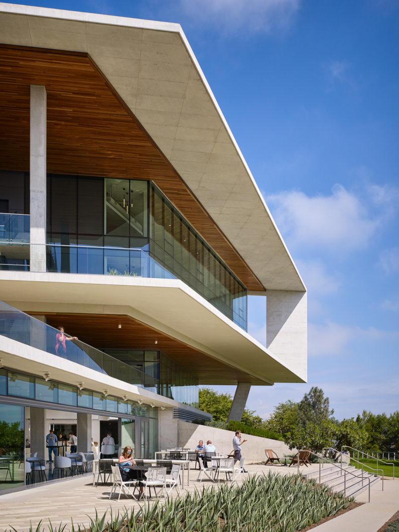 i3 Illumina cafe terrace with vegetation and outdoor seating.