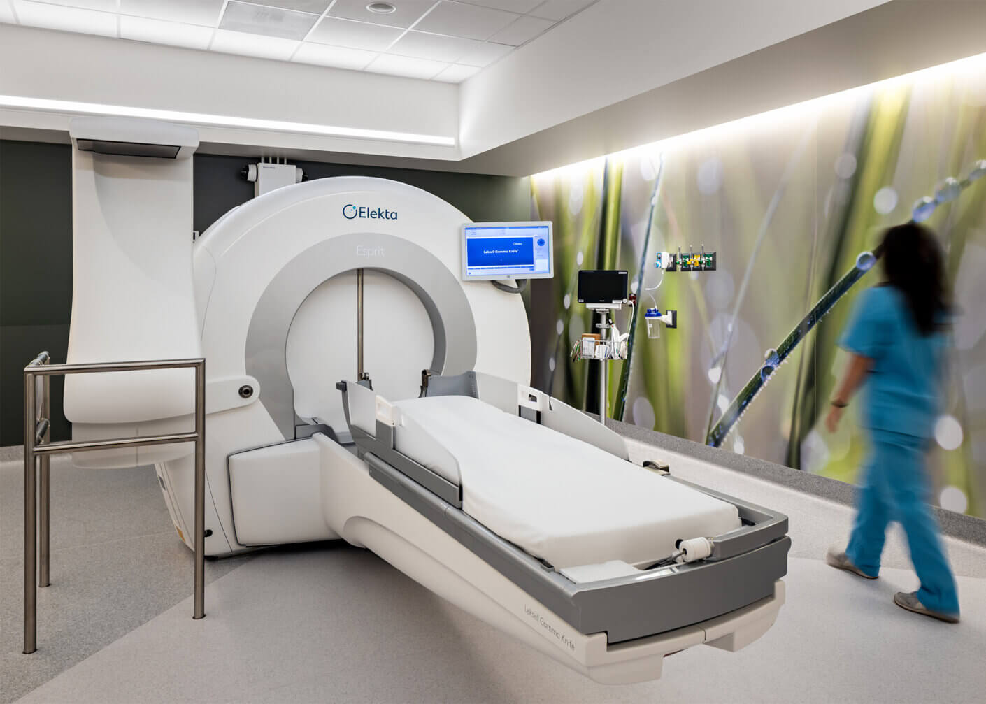 MRI machine in hospital room with medical staff walking.