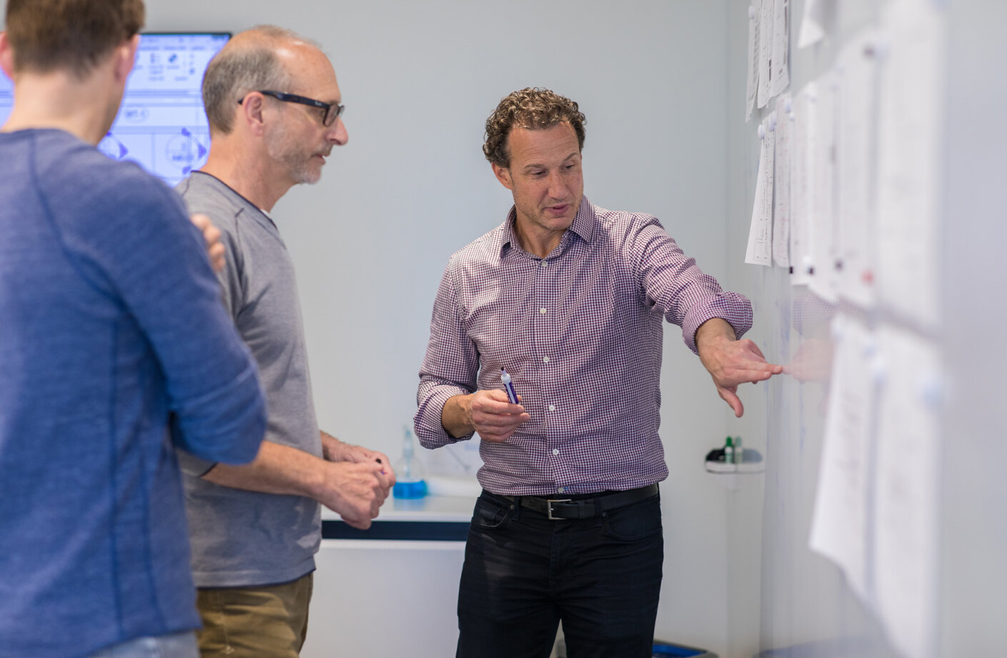 Devin collaborating with two other architects on a white board