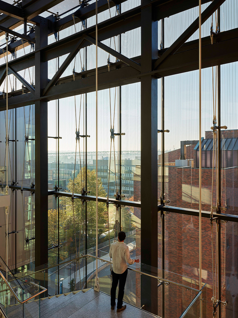 Devin standing on stairs inside the glass box atrium in the life sciences building