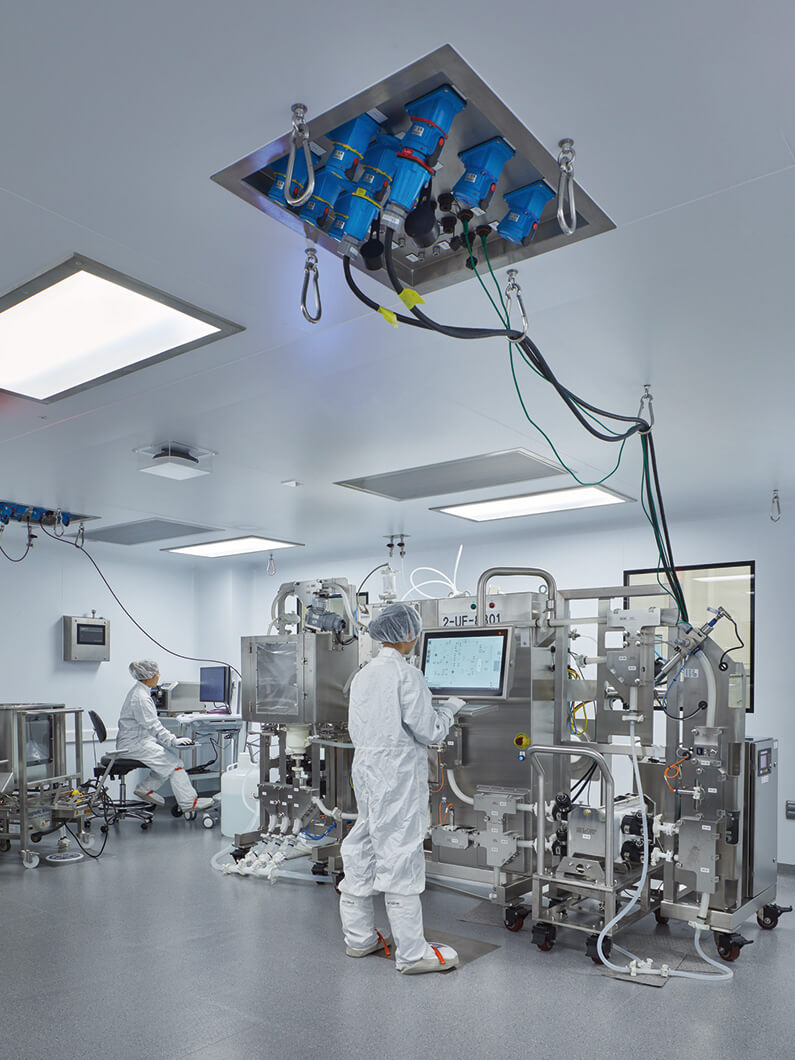 cGMP lab with people working in full PPE