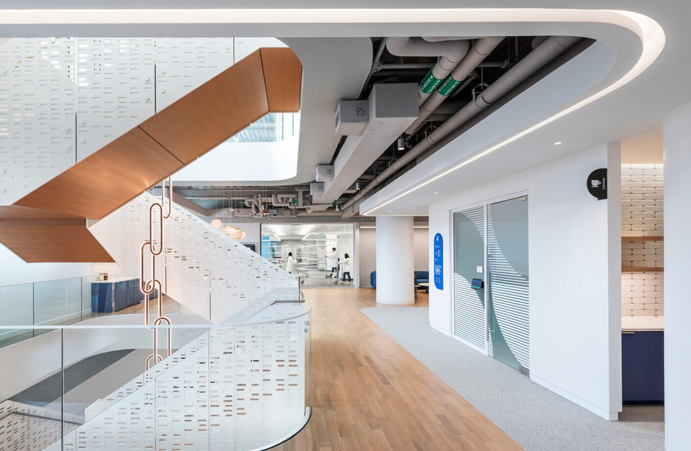 Office space with view to automation lab in back and interconnecting stair in foreground