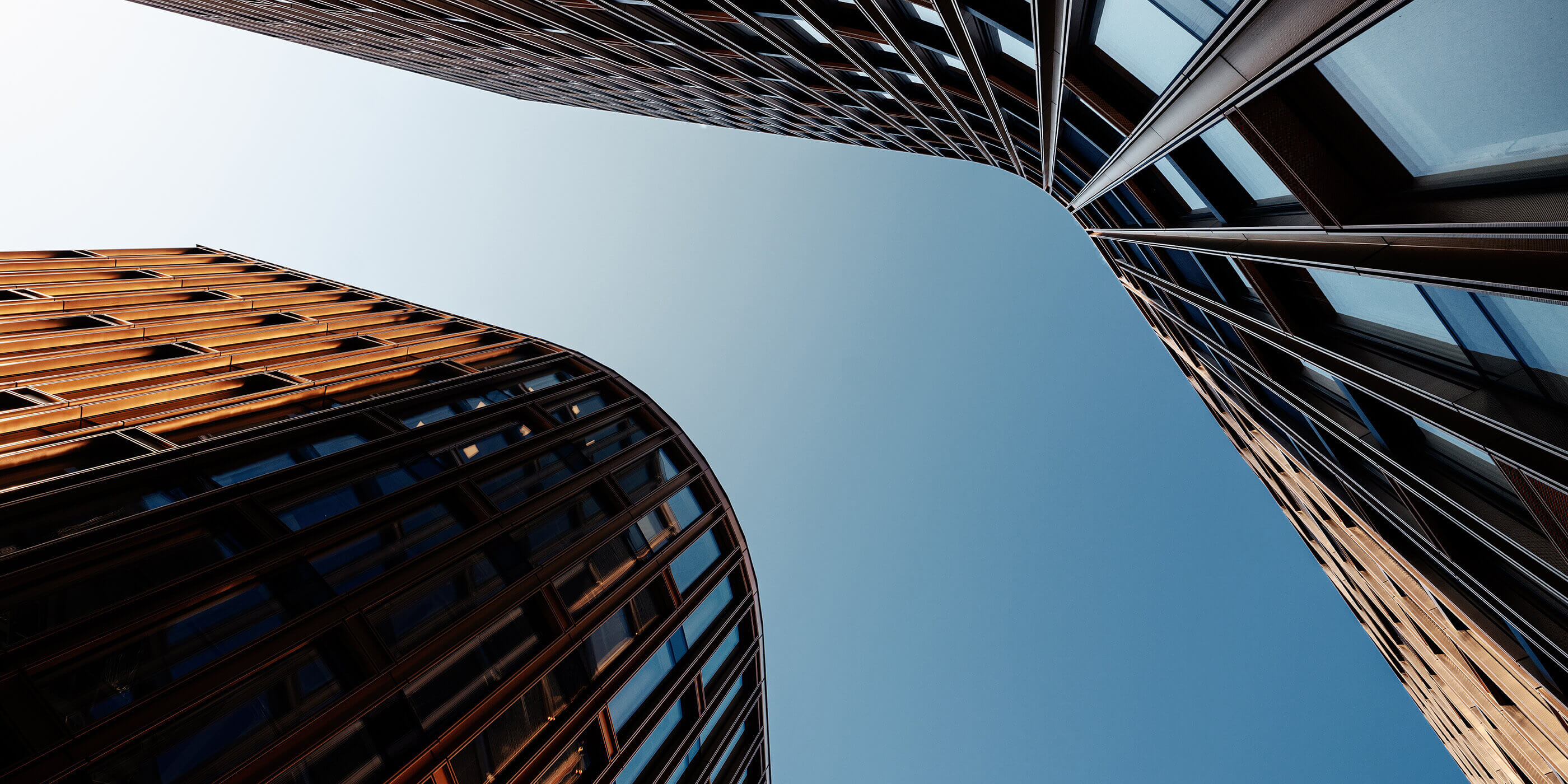 Photo with low vantage point looking up at adaptive re-use, mixed-use building silhouetted against the sky