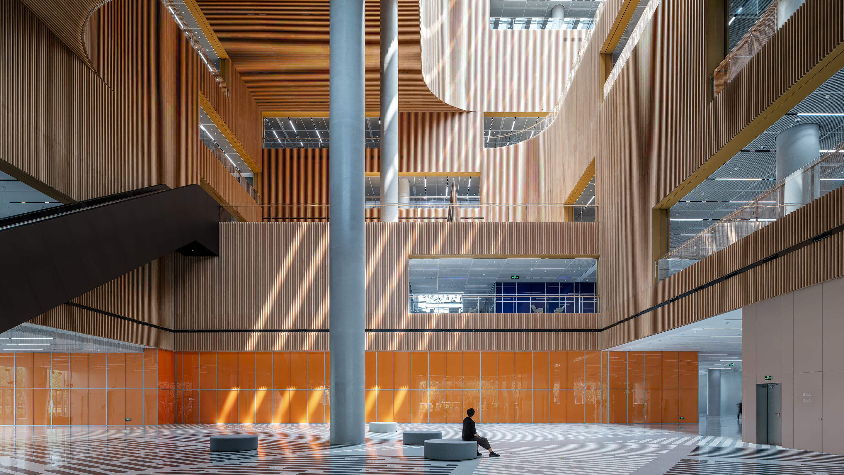 Interior photo of Shanghai Library East showing natural daylight, stair, and curving forms.