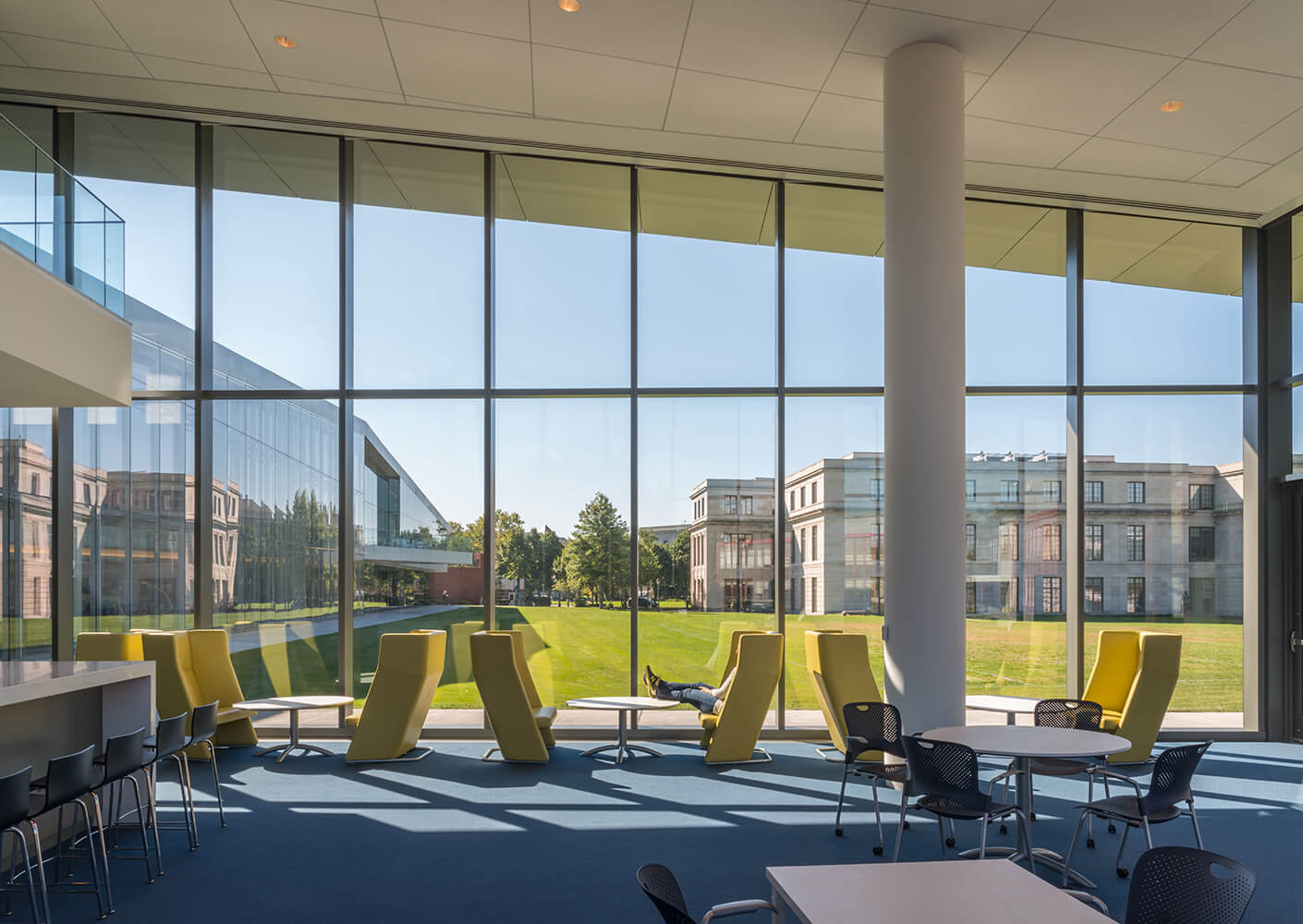 Photograph of interior view through glass curtain wall onto the landscape