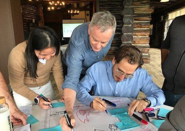 Peter Pfau at the drafting table with colleagues.