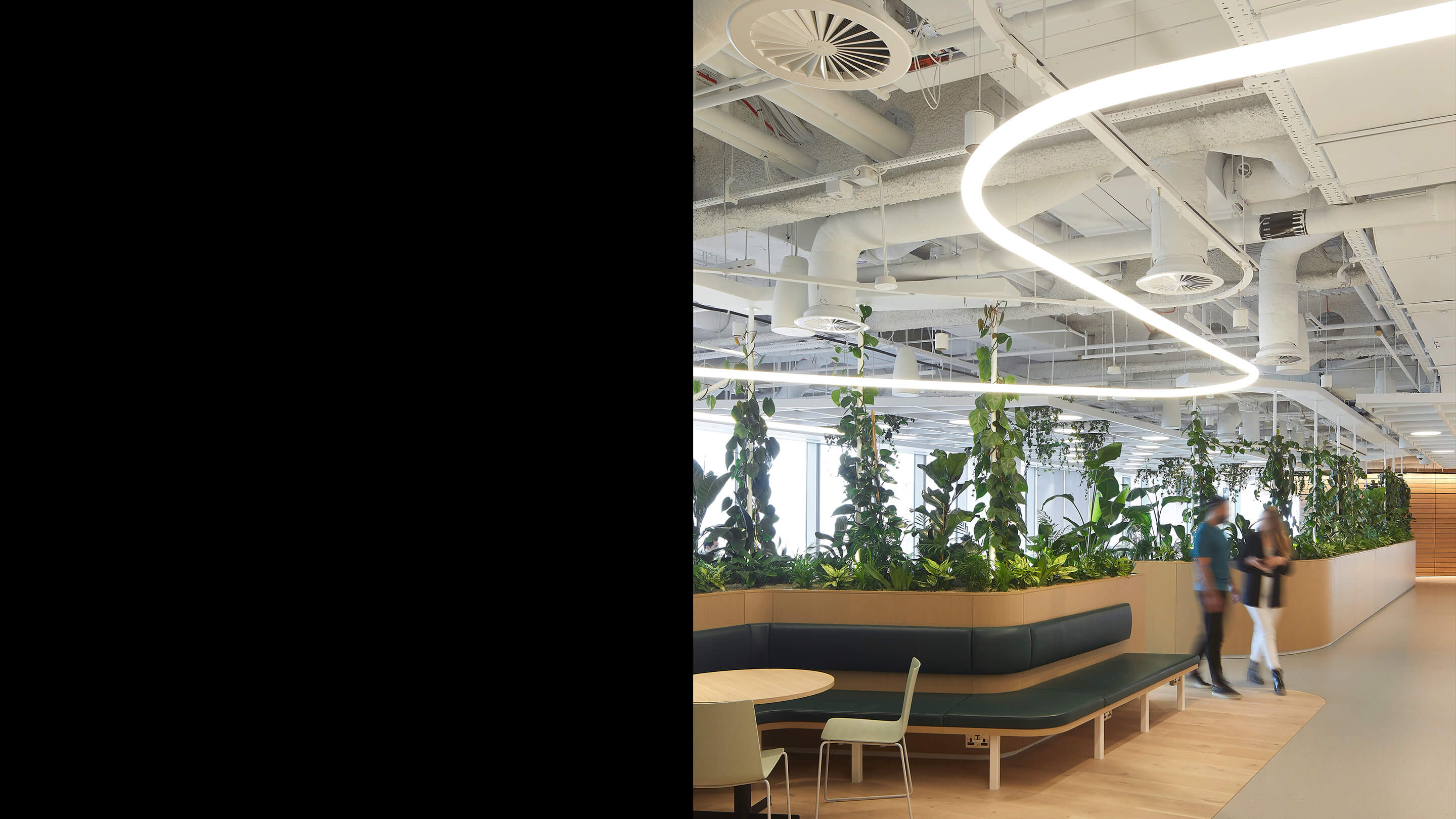 Light fixtures pick up the winding river form, as seen here on level 24, where community and human connection are fostered over food at the restaurant and café.