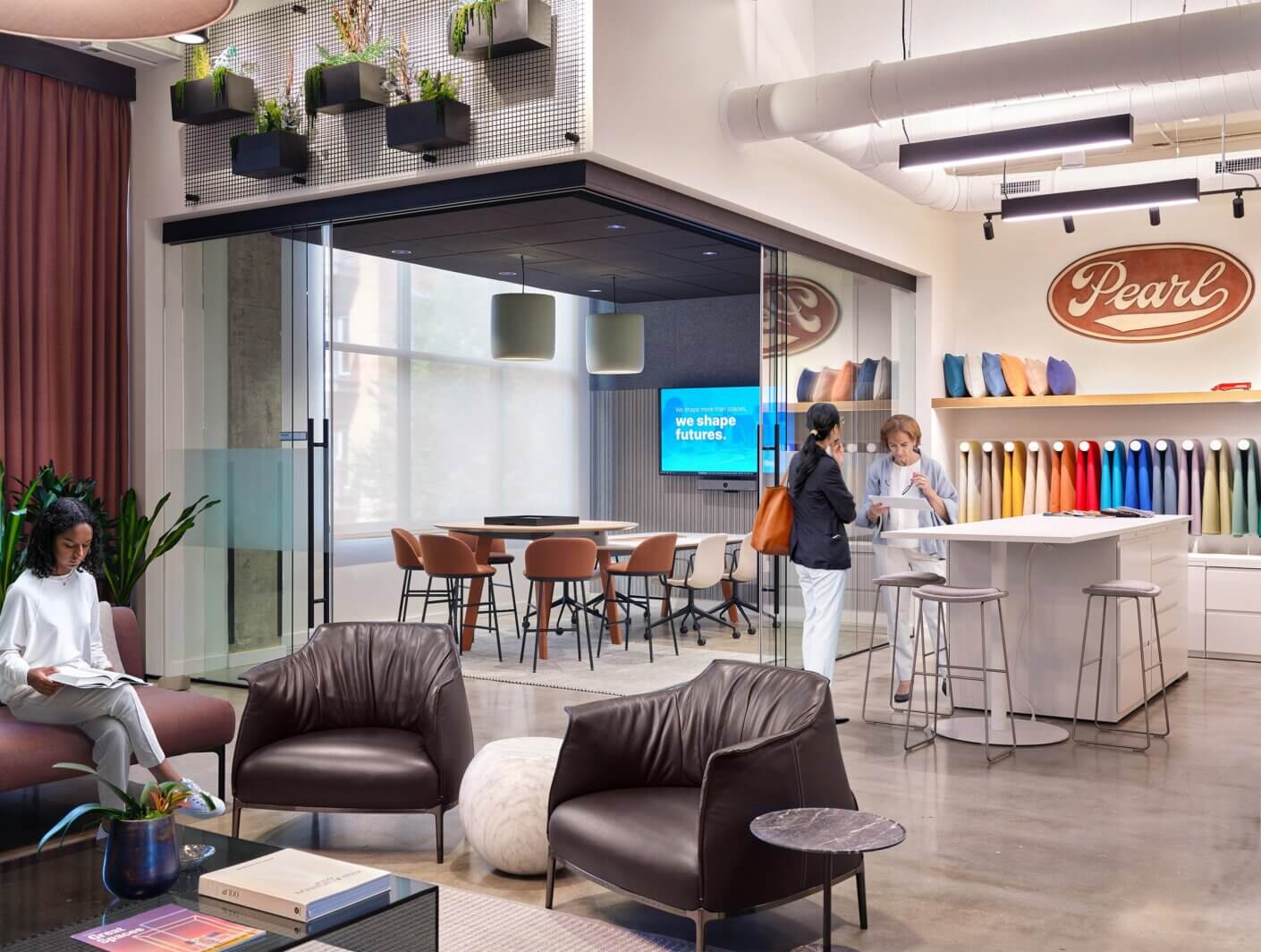 Interior workspace featuring a cozy lounge area, collaborative seating, and a color display for design materials at Pearl.