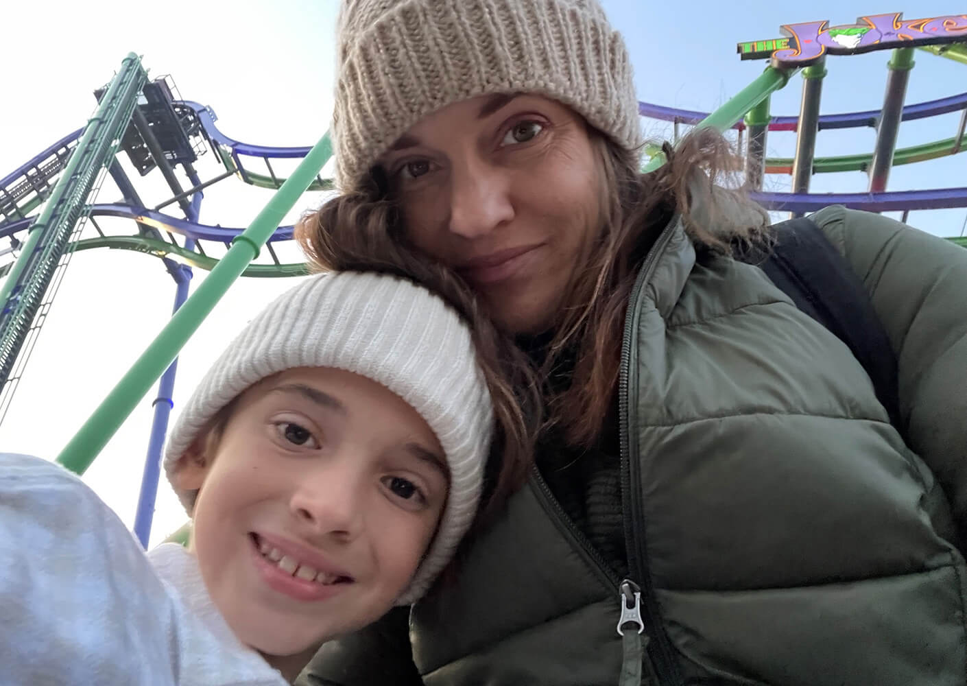 selfie of lindsey with her son in front of a rollercoaster
