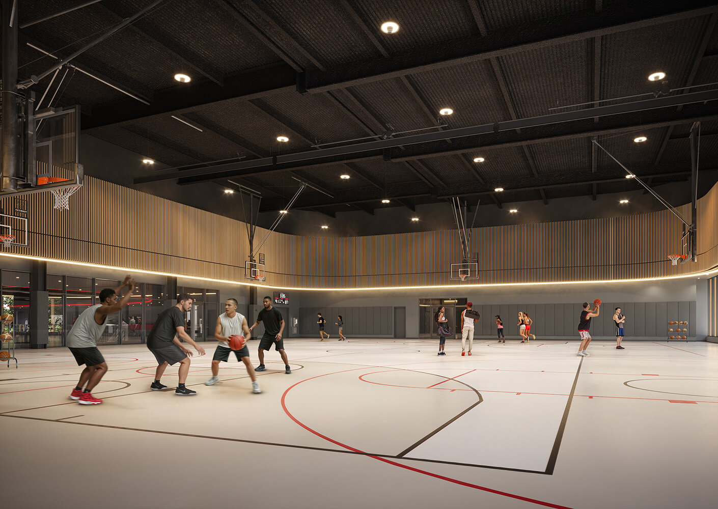 Basketball players engaged in a game inside a gym with wooden accents and bright lighting, featuring multiple basketball hoops and a spacious court.