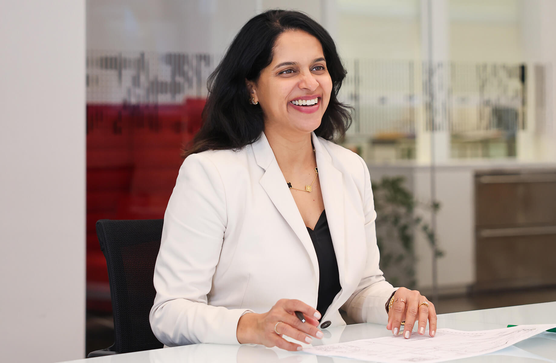 Vandana sits at a table smiling