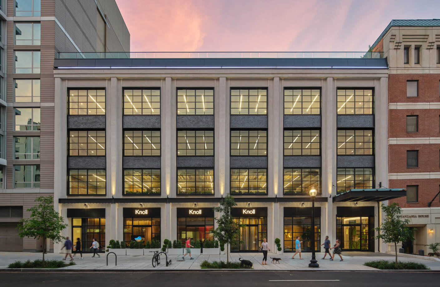 Exterior of industrial city building at sunset with people walking on street