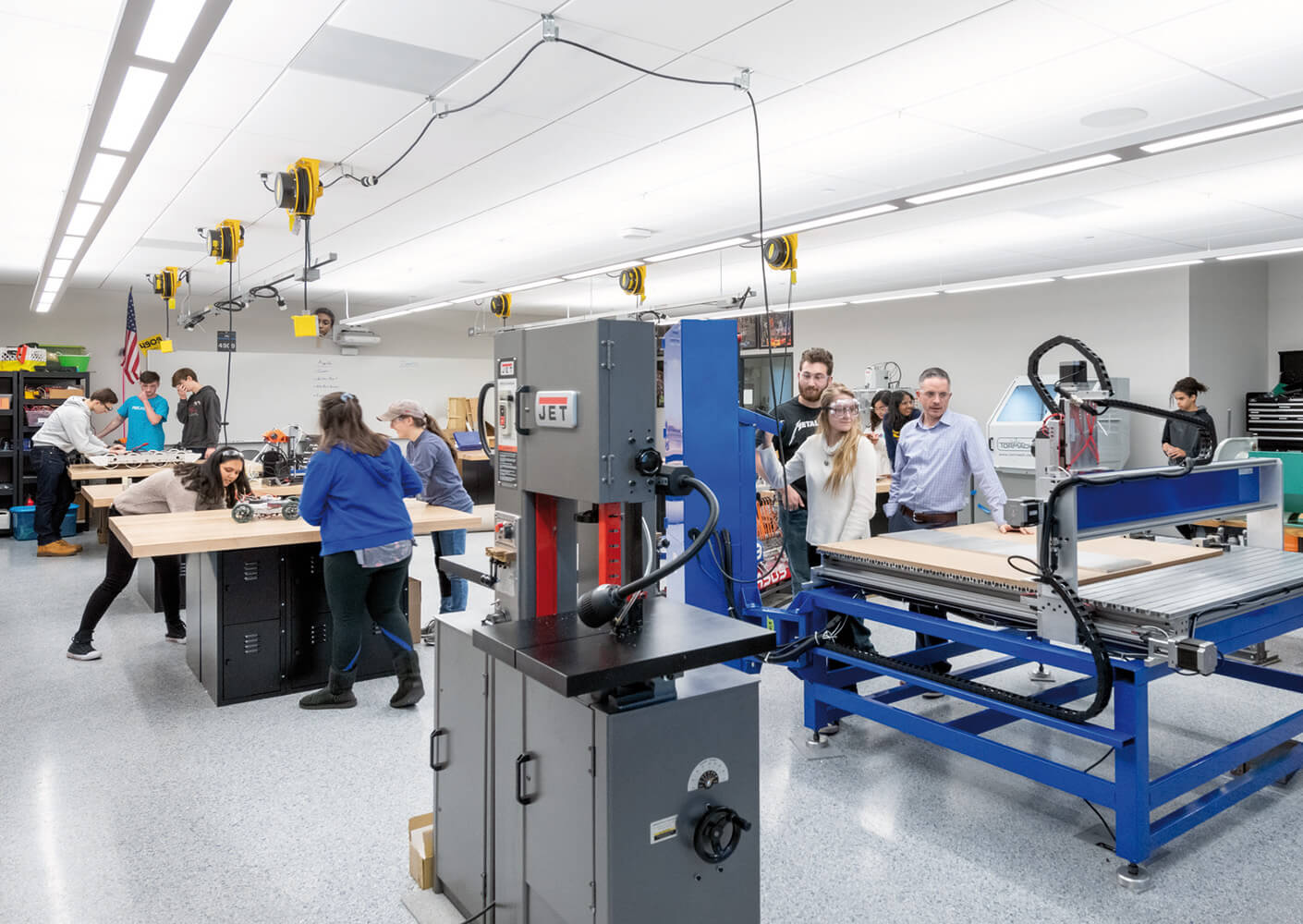 Students collaborating in a modern makerspace with tools and equipment for hands-on STEM learning and innovation.