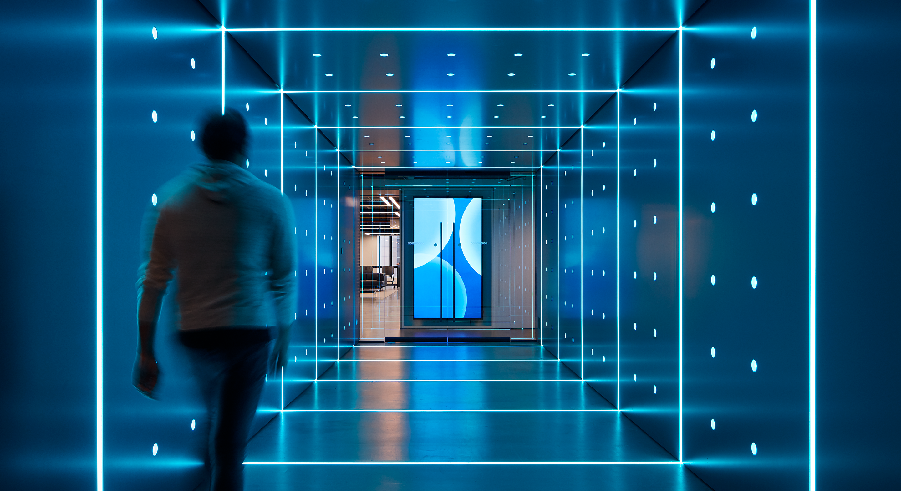 Futuristic hallway with blue neon lights and blurred figure walking toward abstract door.