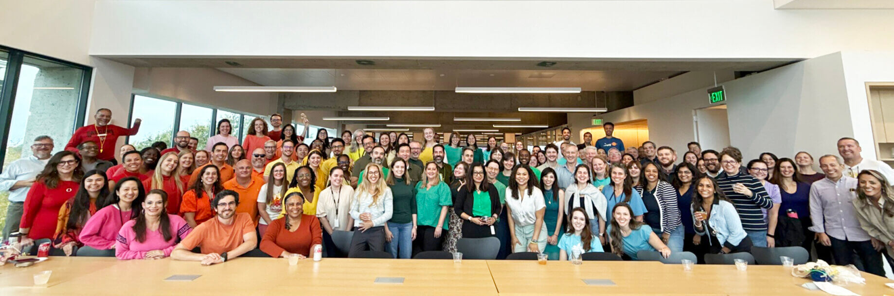 Diverse group of people smiling in a modern office setting.