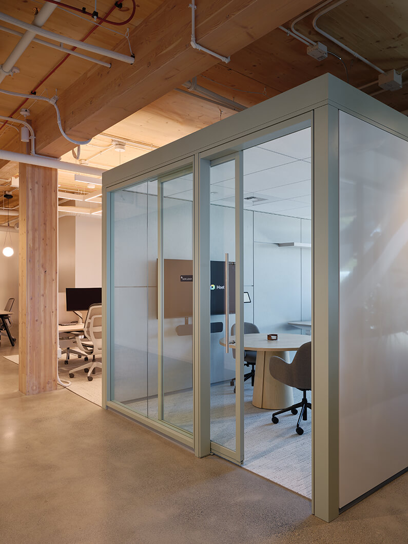 Modern office meeting room with glass walls and sleek furniture.