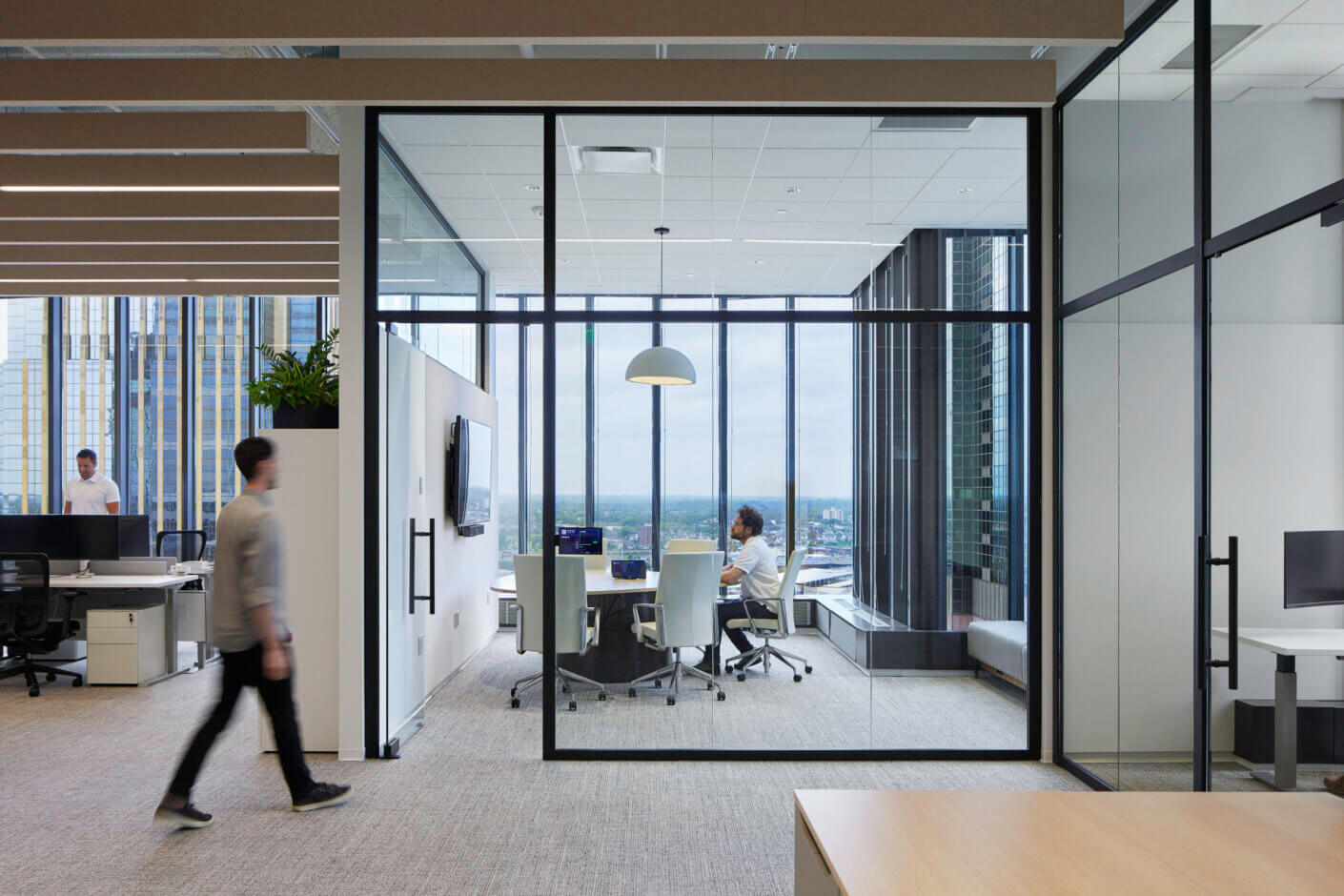 Modern office with glass meeting room and city view.