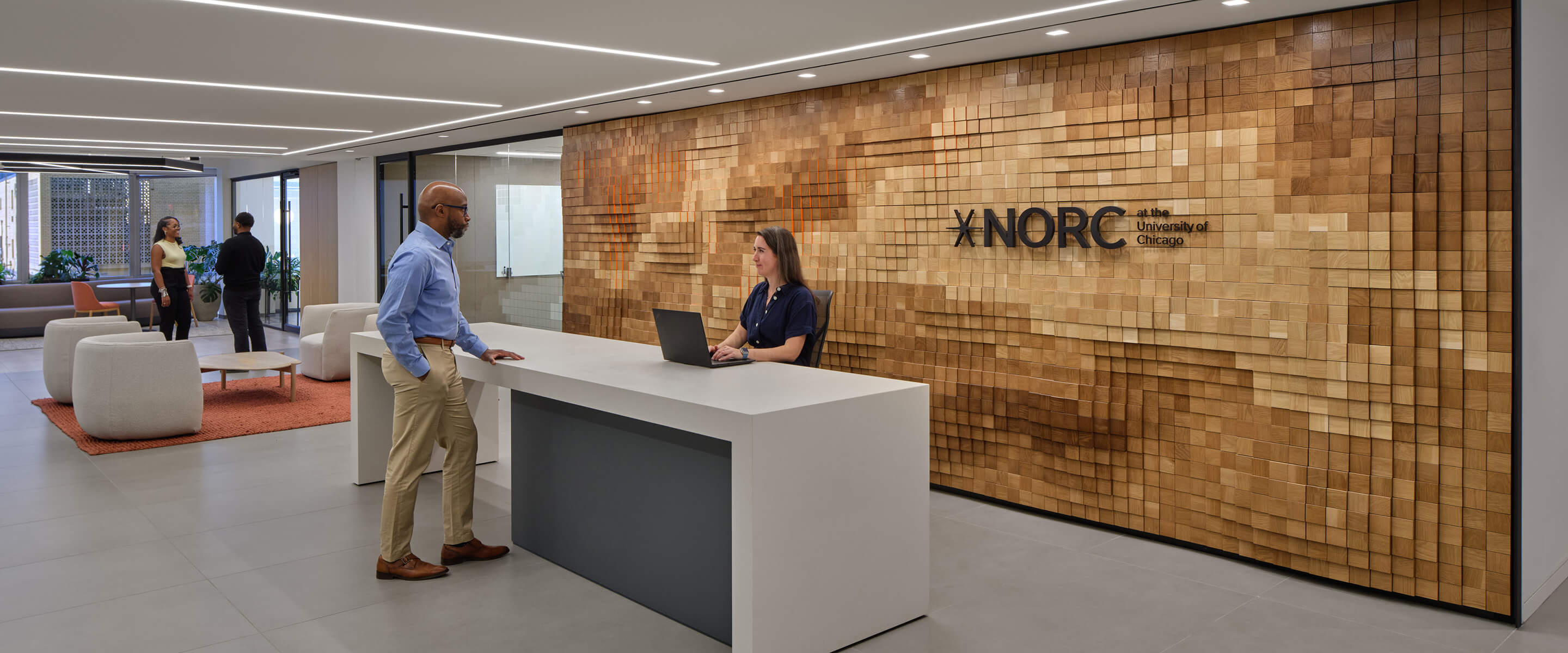 Modern office reception at NORC, University of Chicago, with people interacting.