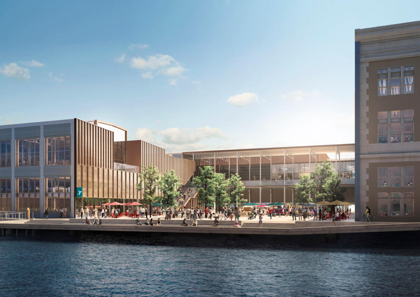 Modern waterfront building with people gathering outside under a clear blue sky.