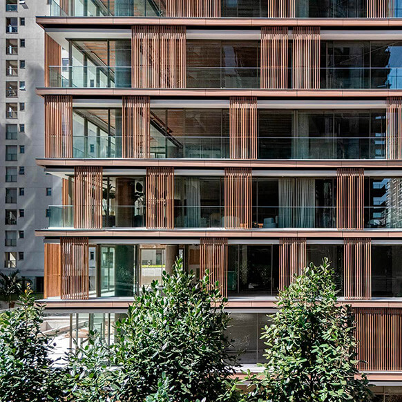 Modern building facade with wooden accents and glass balconies.