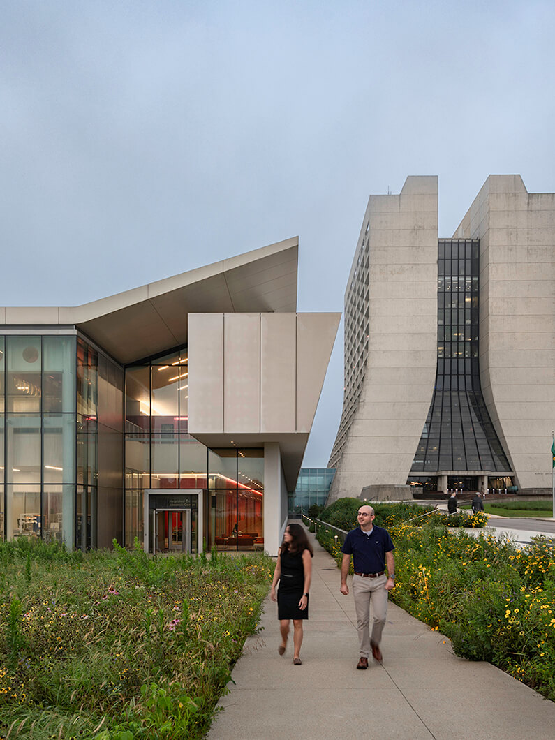 Modern architectural buildings with people walking on a path nearby.