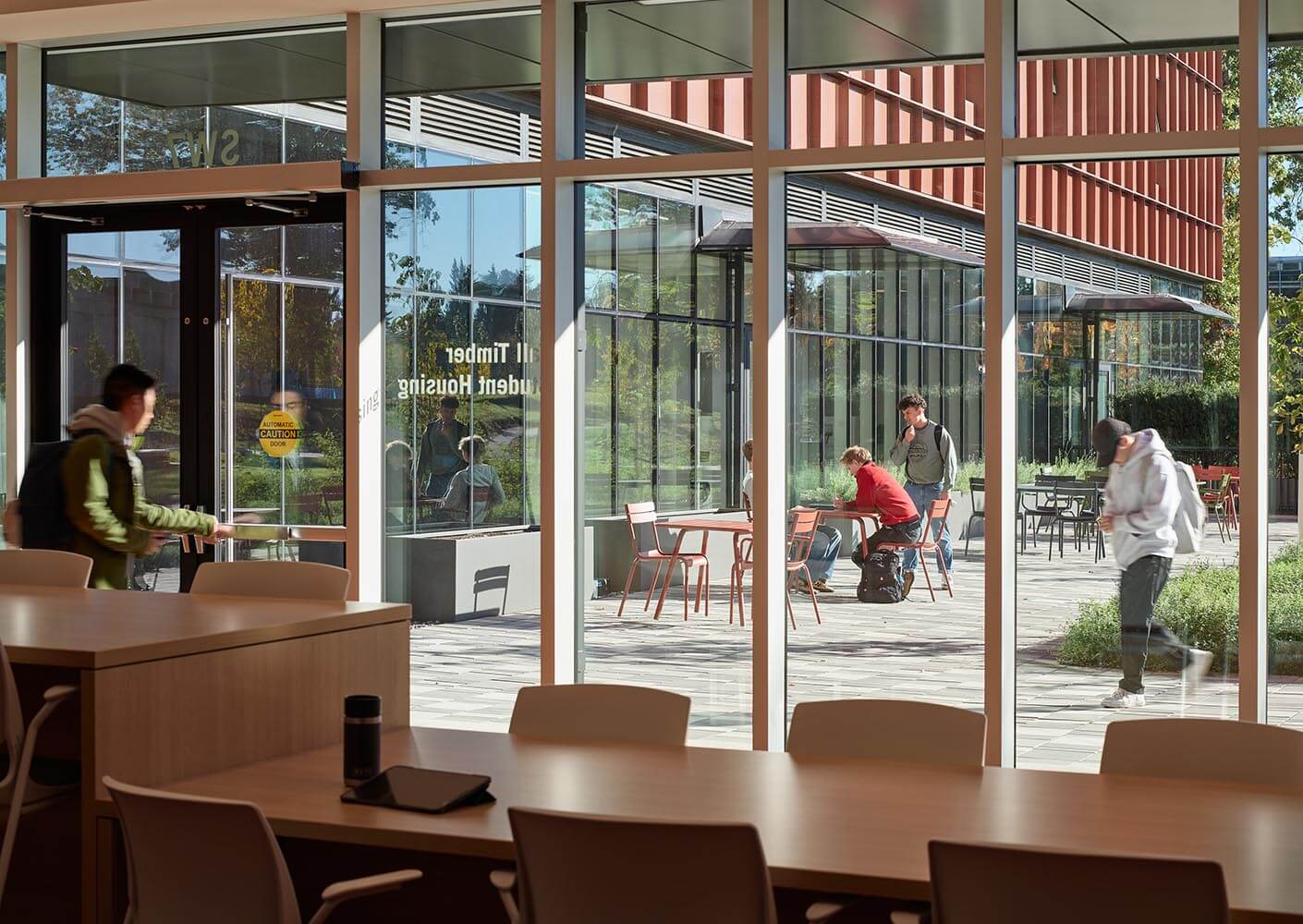 Modern university campus with students studying and walking outdoors.