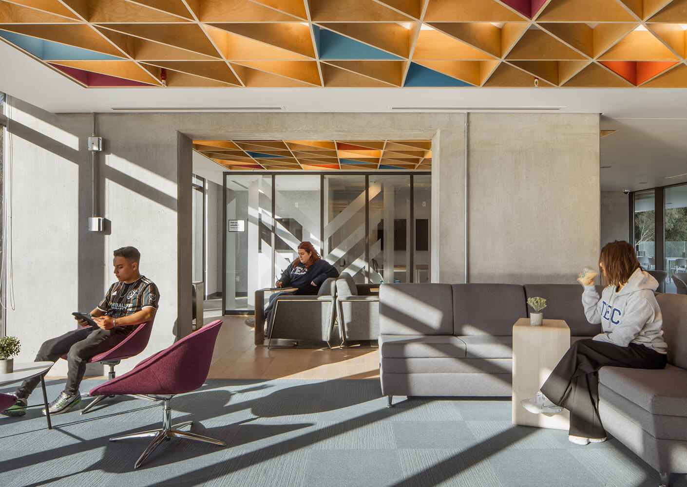 Modern lounge area with colorful ceiling and people relaxing.