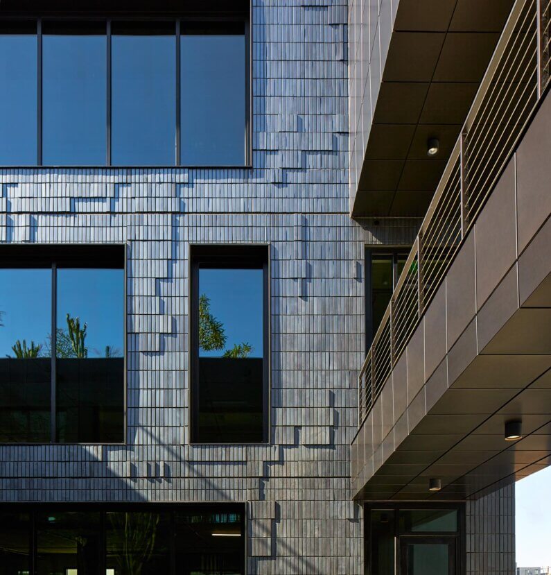 Modern building facade with large windows and balcony.