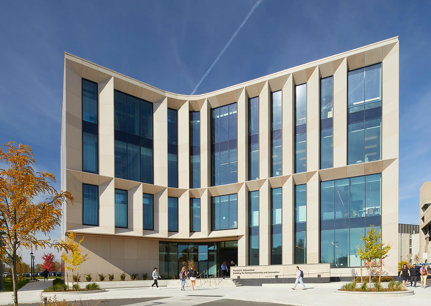 Modern building facade with large windows under a clear blue sky.