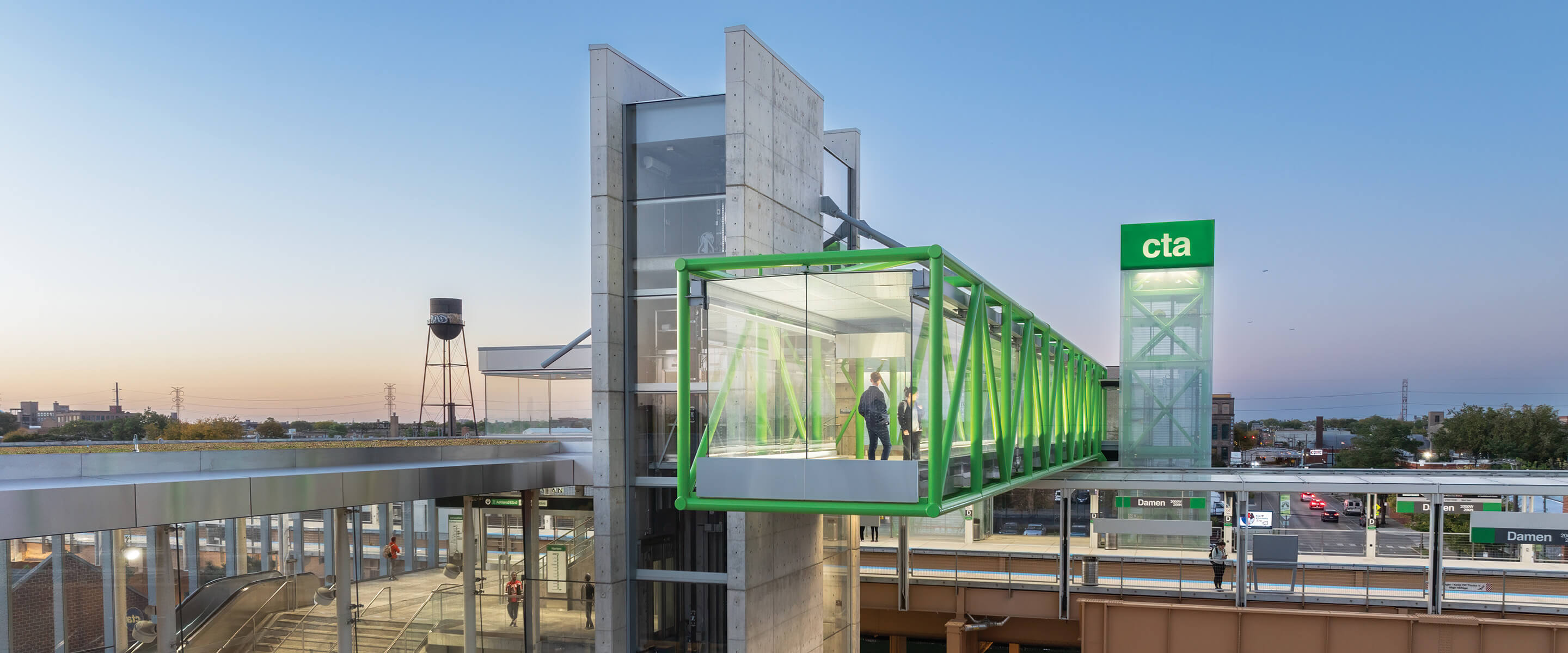 Modern public transit station with glass walkway and green structural details