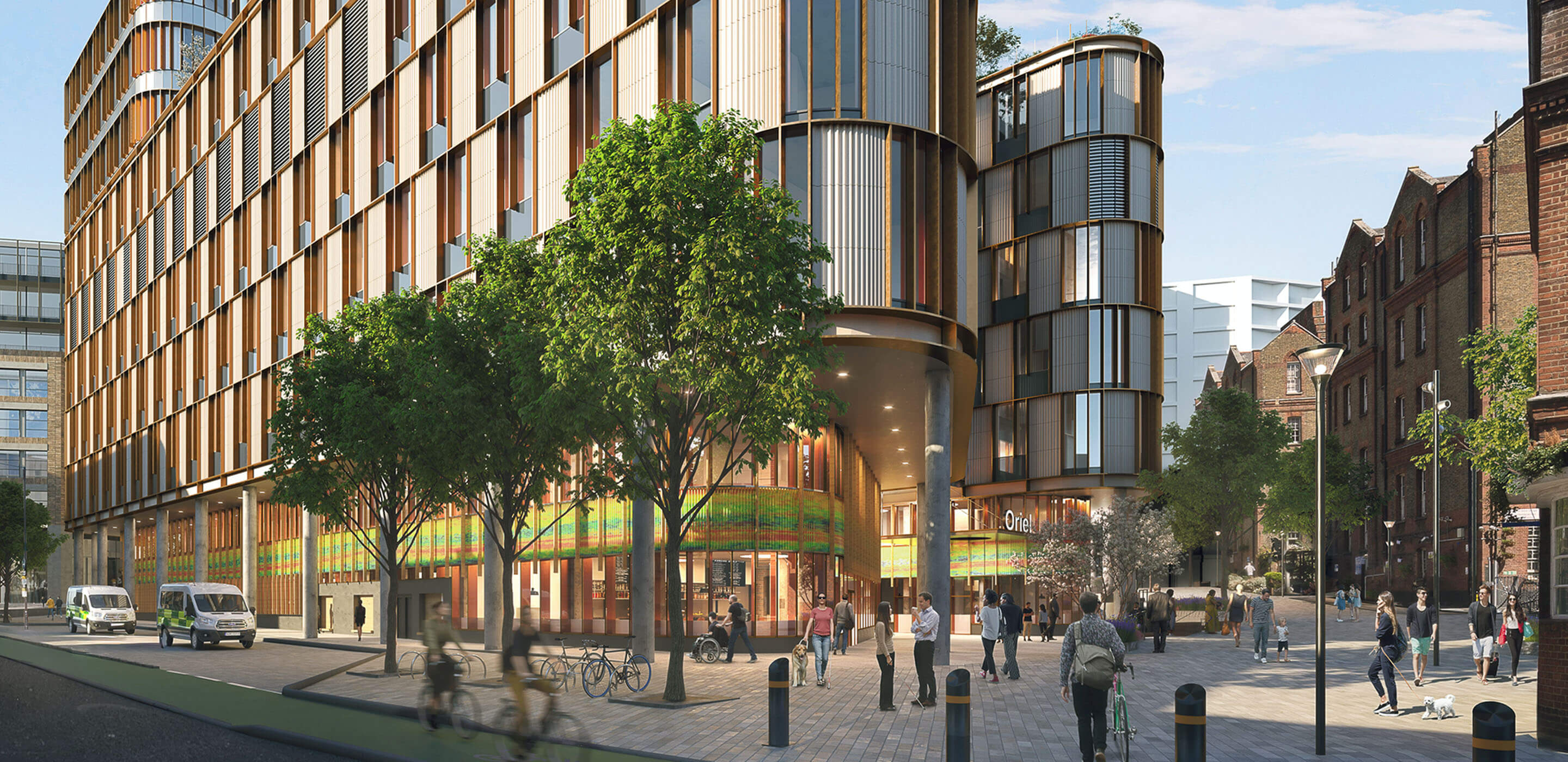 Modern lab building with glass facade, people and bicycles in foreground. A sign says 