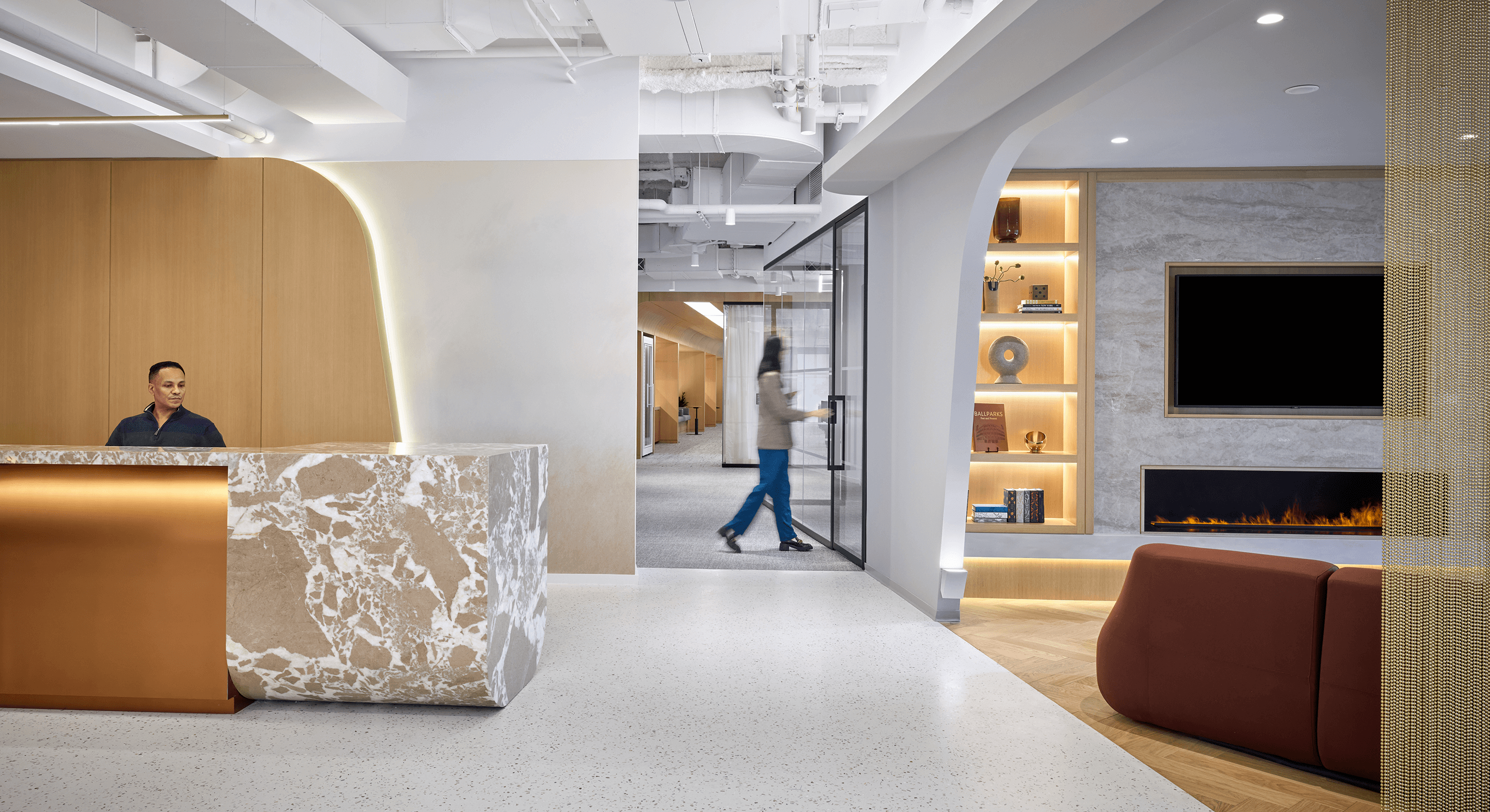 Modern office lobby with receptionist and cozy lounge area.