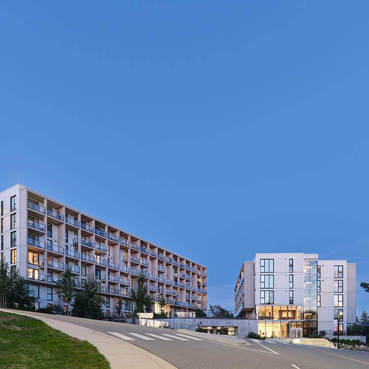 Modern apartment buildings under a clear blue sky.