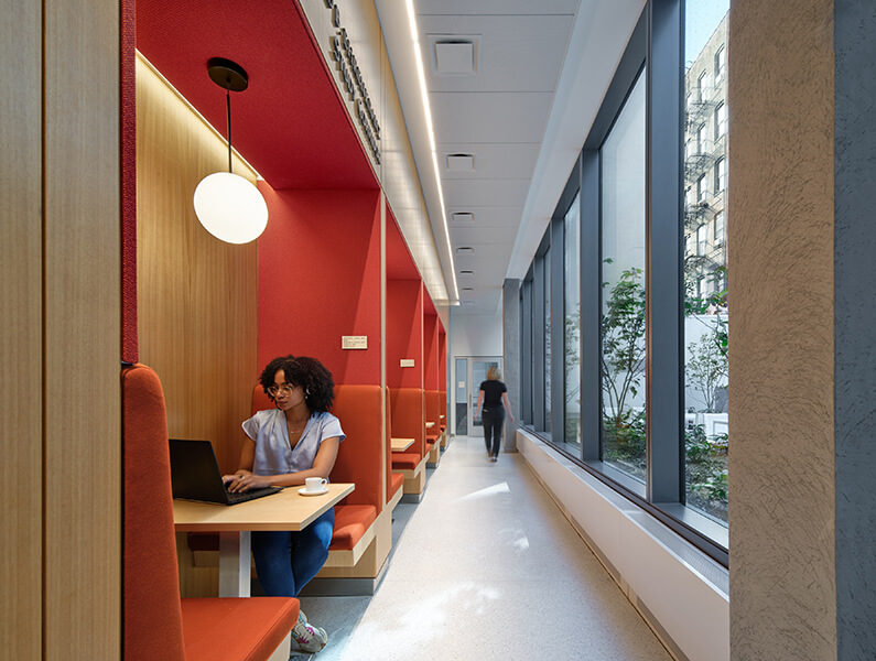 Quiet student workspace with red booths and large windows.
