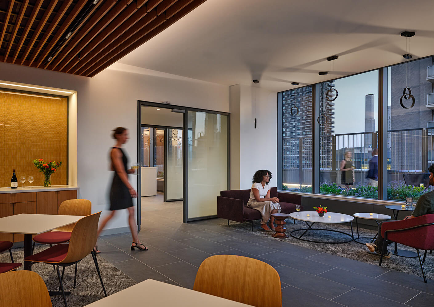 Prefunction event lounge area with people and city view through large windows.
