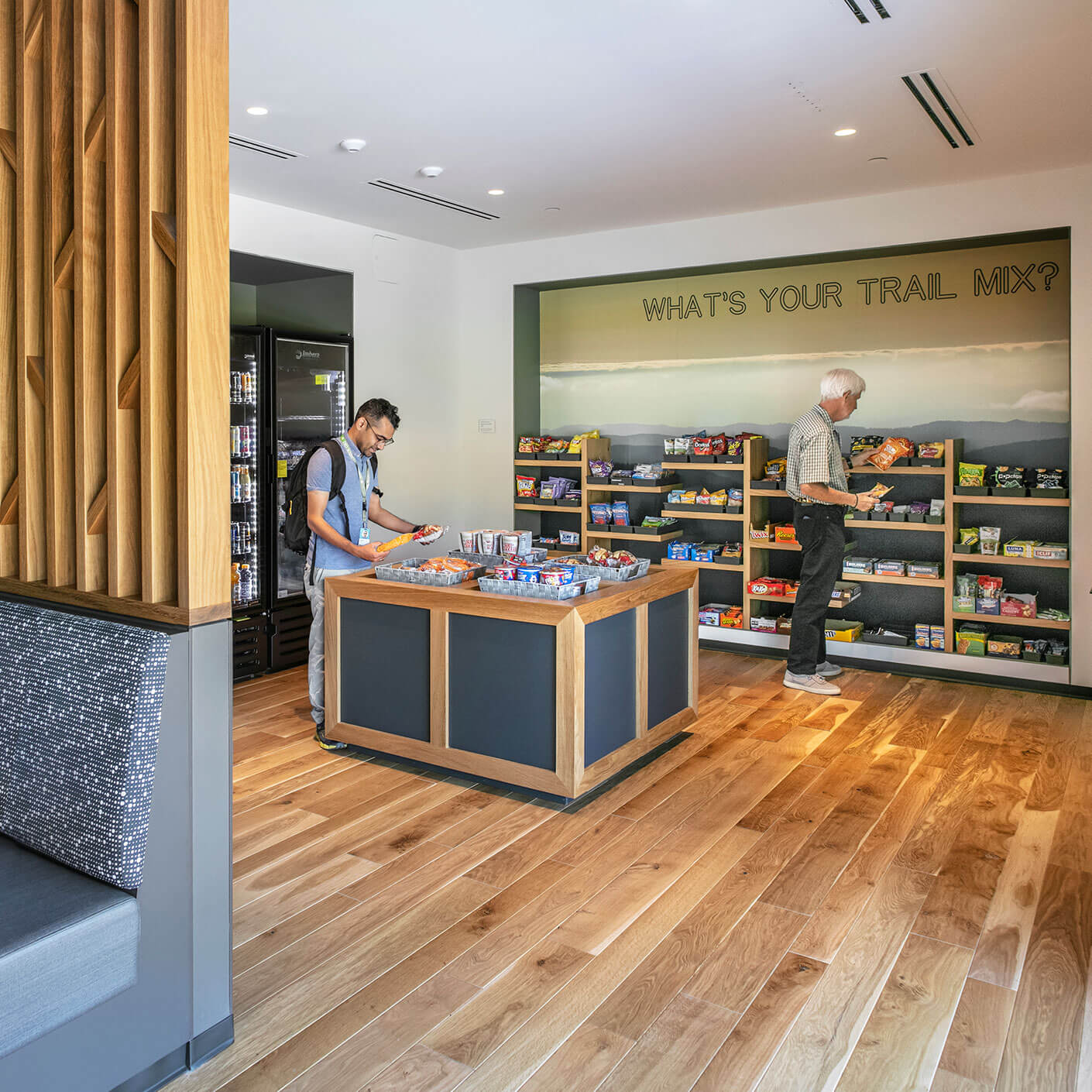Men choosing snacks in a modern convenience store with wooden floor.