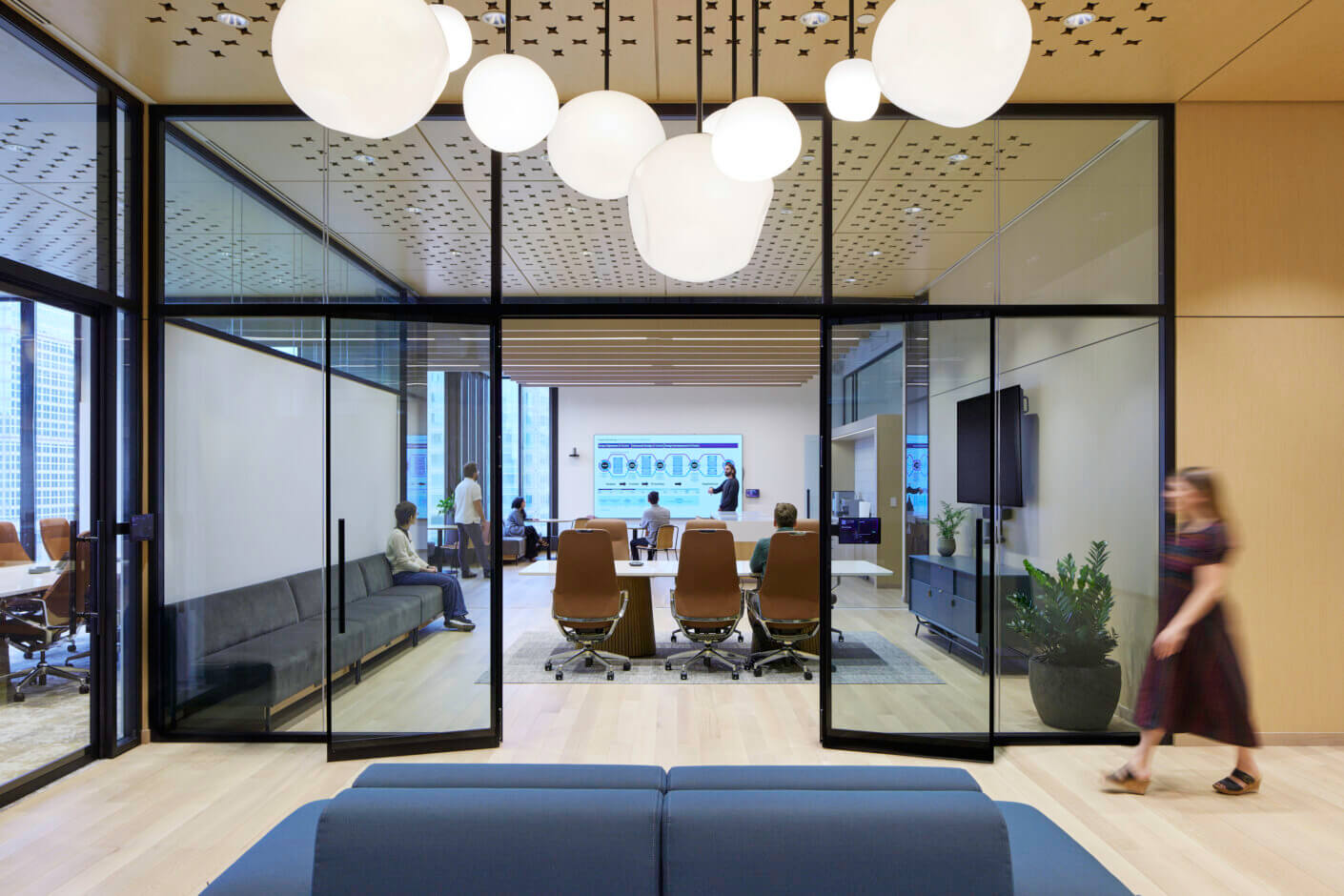 Modern office with meeting room, glass walls, and contemporary furniture.