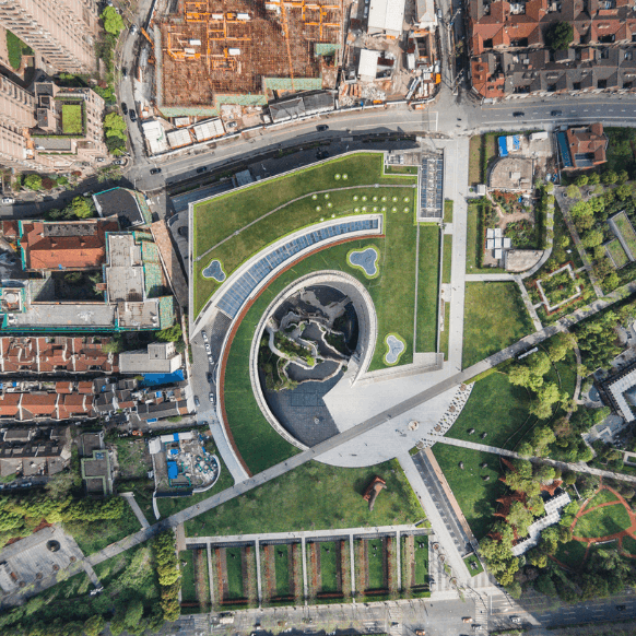 Aerial view of a modern green park with winding pathways and landscaped areas.