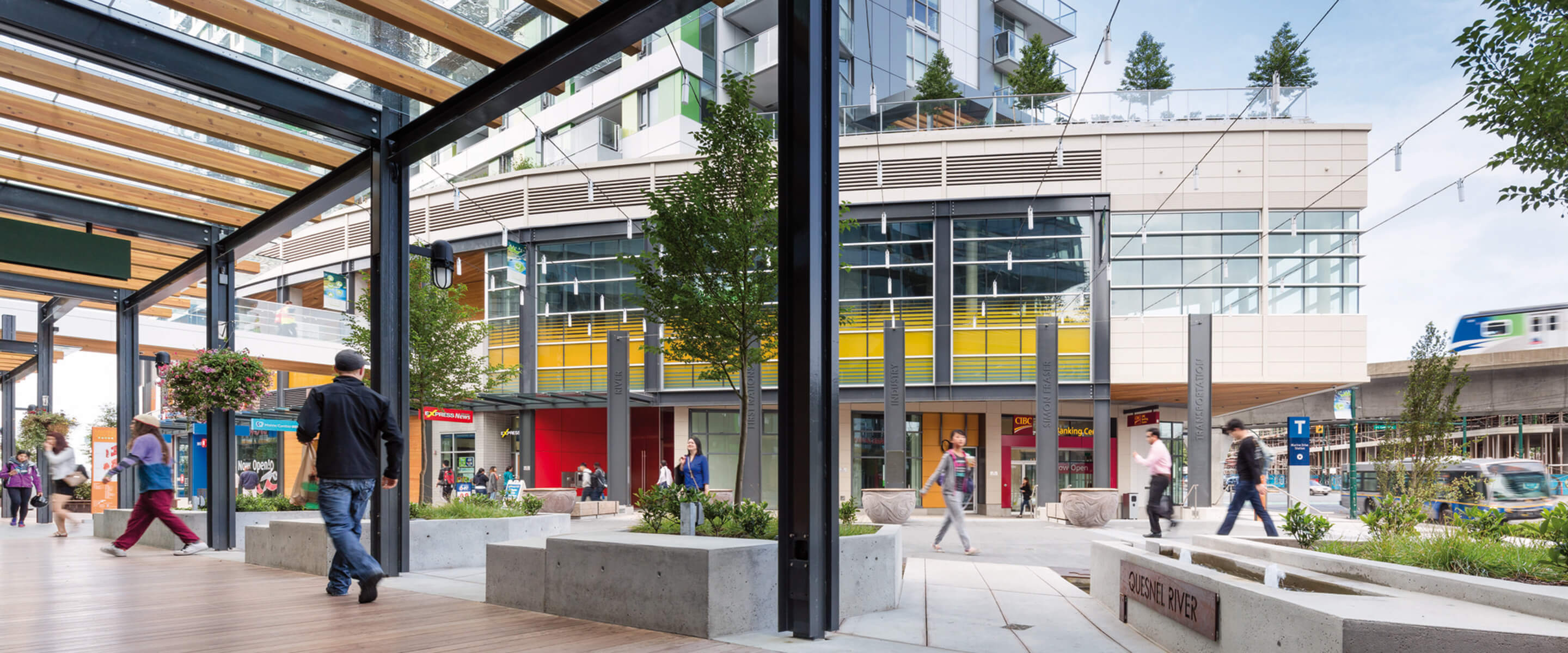 Modern urban plaza featuring sleek buildings, wooden beams, and landscaped greenery.
