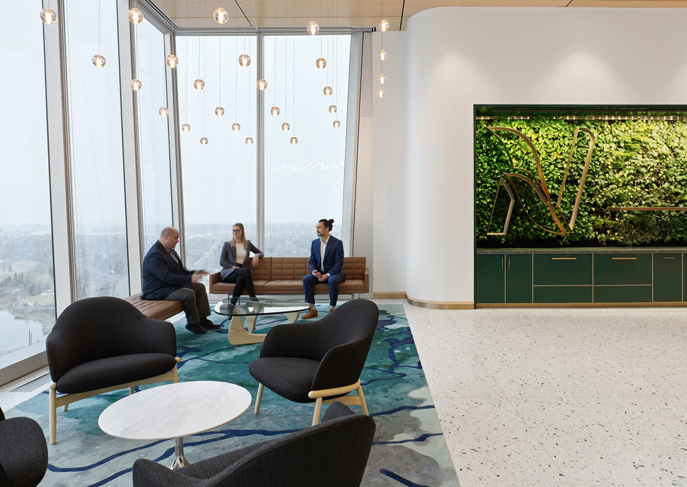 A spacious office lounge with large windows, featuring three professionals discussing ideas near a greenery wall and stylish furniture.