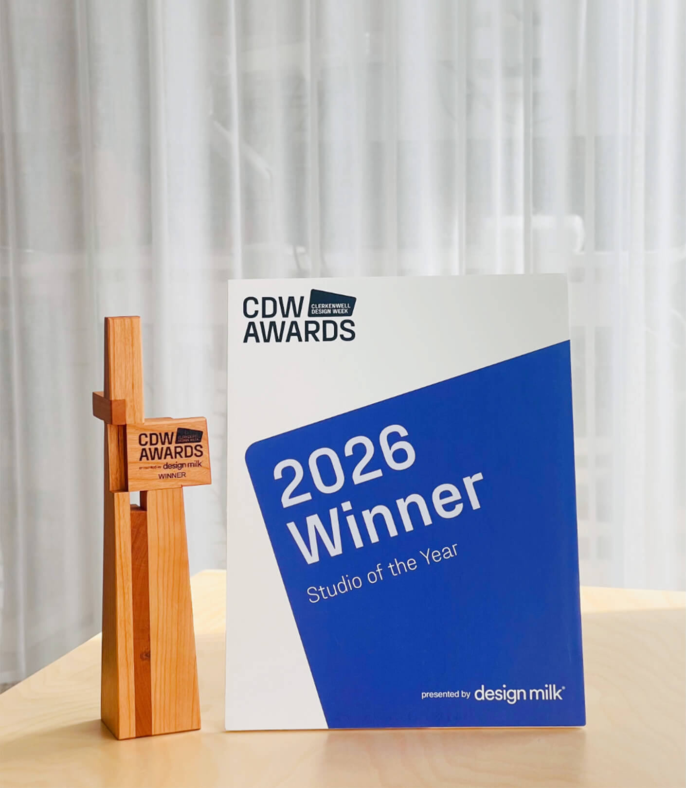 Award trophy next to a certificate from the CDW Awards, recognizing a studio as the 2026 Winner for Studio of the Year, presented by Design Milk.