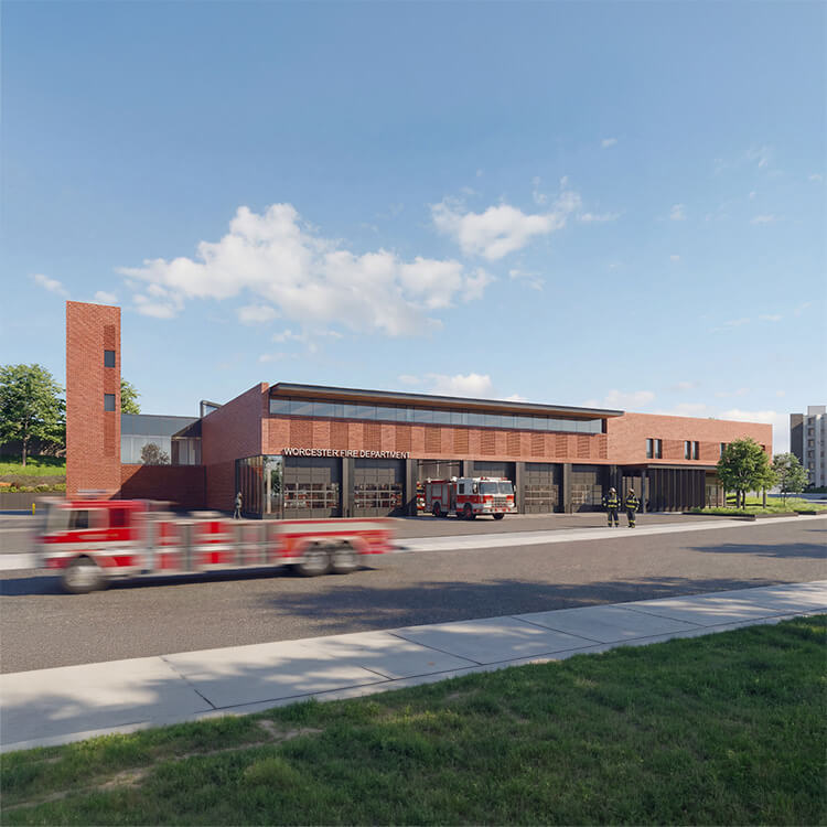 Exterior view of the Worcester Fire Department building, featuring a red brick façade, large glass windows, and parked fire trucks.