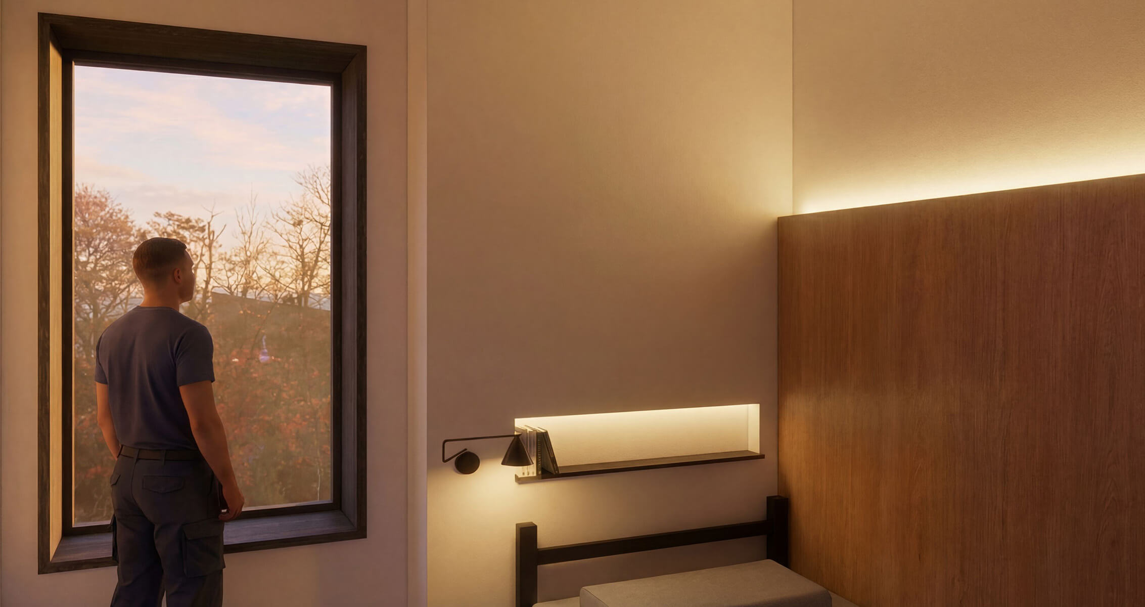 A person stands by a large window, looking out at trees, with a minimalist bedroom featuring warm lighting and simple furnishings.