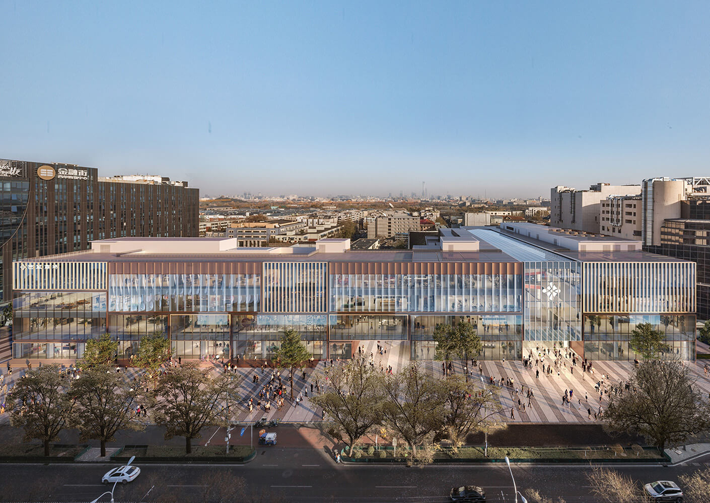 Aerial view of a commercial building with large glass windows, surrounded by trees and pedestrians, set against a clear sky.