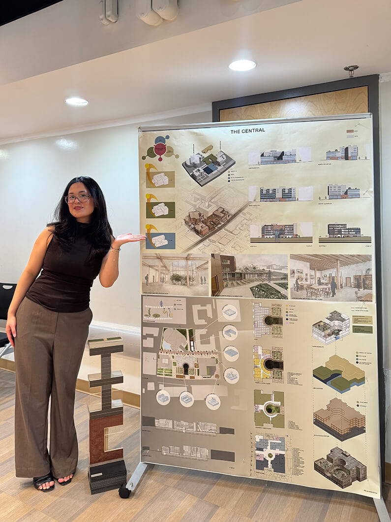 Person presenting an architectural project board titled The Central, showcasing design layouts and visual plans in an indoor setting.