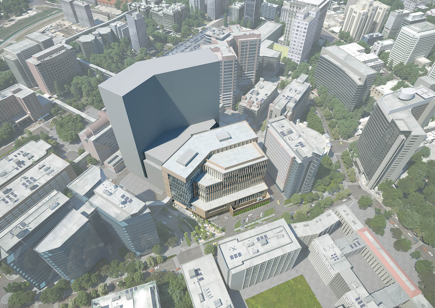 Aerial view of an urban area featuring various buildings, emphasizing a large architectural structure at the center. Green spaces are visible nearby.
