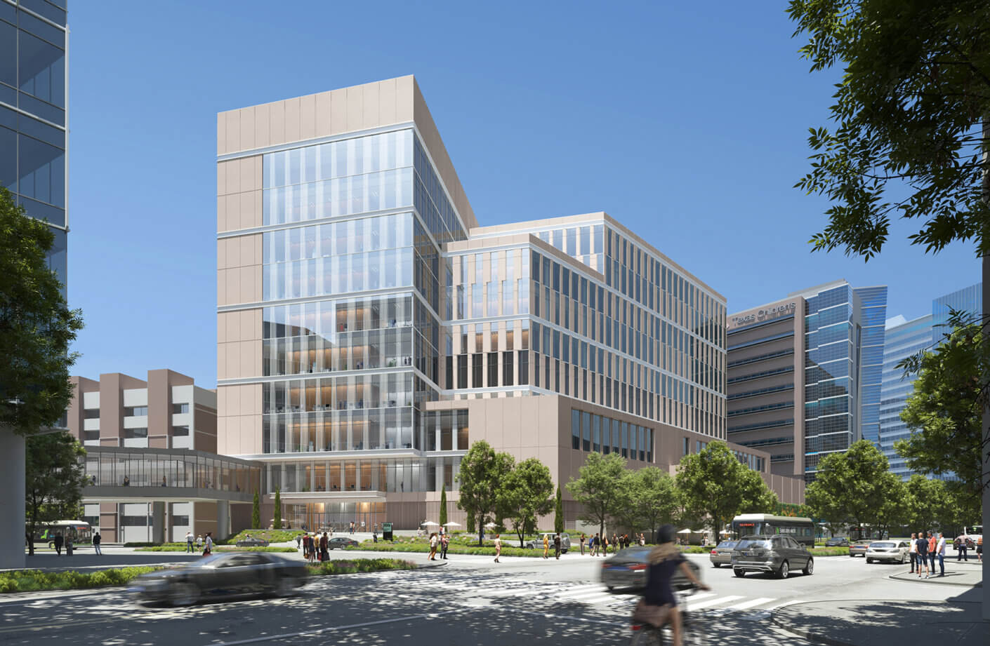 Clinical services building with glass and stone façade, surrounded by landscaping and pedestrians, located in an urban setting. Sunny sky overhead.